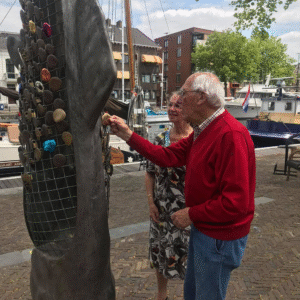 Mensen bewonderen de schubben aan het kunstwerk
